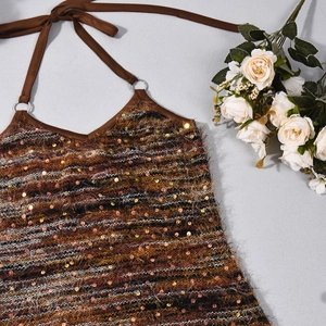Dettaglio della trama dell'abito in maglia con paillettes marroni e anelli in metallo