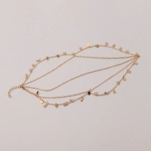 Detail of bohemian gold multi-layer head chain with round sequins and metallic texture