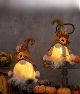 Detail leuchtender Thanksgiving-Zwerge mit Sonnenblume und Ahornblatt auf Leinwand