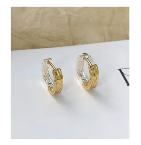 Detail view of U-shaped two-tone earrings with unique hammered texture and silver inner ring