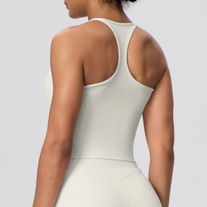 Detail view of racerback design on cream yoga tank top with soft breathable fabric