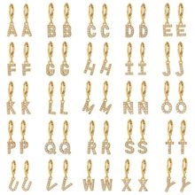 Detailed grid showing 26 pairs of gold-plated huggie hoop earrings with A-Z letter charms