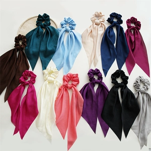 Flat lay of 12-color satin ribbon scrunchies set with silky texture and long streamers