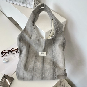 Detail of grey tie-dye canvas tote bag showing textured fabric and minimalist woven label