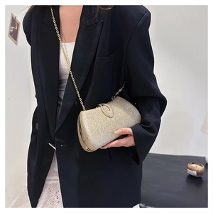Detail of elegant gold glitter evening clutch with diamond clasp and chain strap