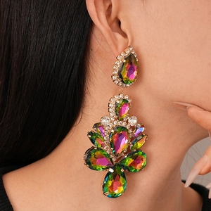 Close-up of model wearing glamorous oversized floral drop earrings with colorful crystals