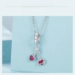 Detailed view of S925 sterling silver cherry pendant with red heart-shaped crystals