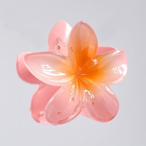 Detailed view of the gradient pink and yellow frangipani flower hair claw clip