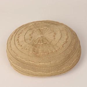 Top view detail of solid color knitted beret featuring layered concentric weave patterns