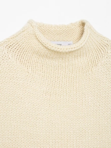 Close-up of cream knit vest collar showing fine texture and European size S label
