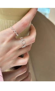 Close-up of minimalist S925 silver beaded rings and geometric open band on finger