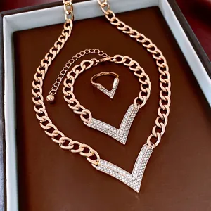 Elegant gold jewelry set with crystal-encrusted V-pendant necklace, bracelet and ring