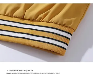 Detail of yellow baseball jacket ribbed elastic hem with black and white stripes