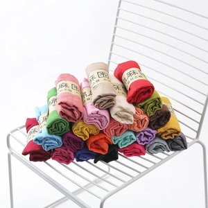 Multi-color pleated cotton linen scarves neatly stacked on a white mesh chair