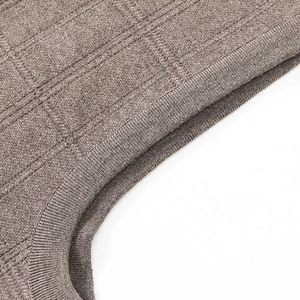 Detailed close-up of brown knit vest neckline featuring delicate textured square weave