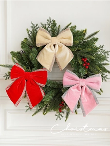 Close-up of velvet Christmas bows in red and pink on a festive green pine wreath
