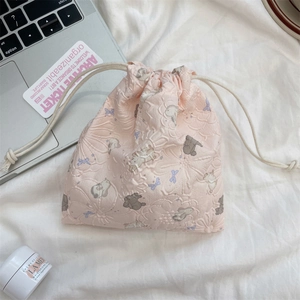 Detailed view of pink quilted drawstring storage pouch with rabbit and floral patterns