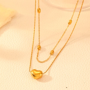 Double-layered gold titanium steel heart pendant necklace with beads on beige leather
