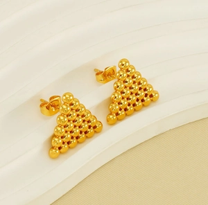 Détails de boucles d'oreilles triangles dorées avec fermoirs papillon sur présentoir