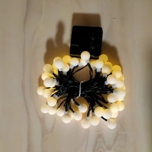 Outdoor solar-powered LED string lights with warm glowing frosted globe bulbs for garden decor
