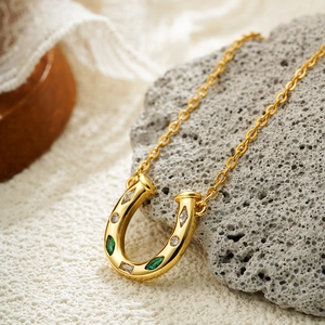 18K gold plated western horseshoe necklace with green and clear zircon stones on a chain