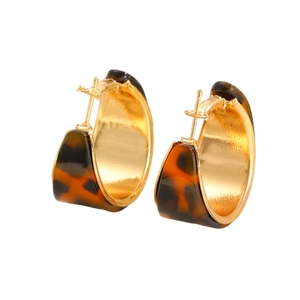 Detail of C-shaped leopard print earrings with polished gold-tone metal inner lining