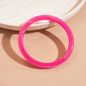 Détail du jonc ouvert en acrylique translucide magenta au design géométrique minimaliste
