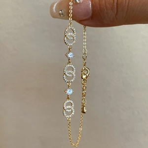 Detailed view of 18k gold plated bracelet with interlocking C charms and shiny zircons