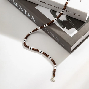 Detail of bohemian necklace with brown wooden beads and black and white stripe accents