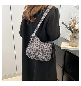 Chic leopard print crescent bag in dark grey worn on shoulder with wide strap