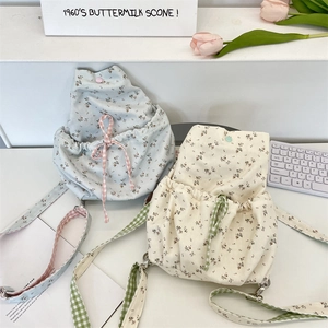 Detail of floral canvas drawstring backpacks with adjustable straps in light blue and white