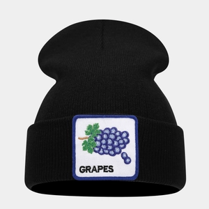 Detail shot of the grape embroidery patch on a black knitted beanie cap