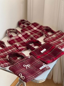 Vue à plat de sacs à main en laine à carreaux rouges avec nœuds et étiquettes de marque