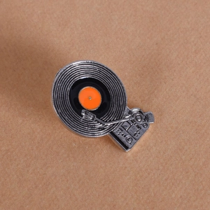 Detailed view of vintage vinyl record player enamel pin with textured silver needle