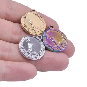Detailed view of cat and star engraved pendants in gold, silver, and rainbow steel