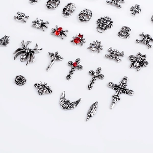 Detailed macro shot of gothic 3D nail art charms featuring vintage silver metal skulls