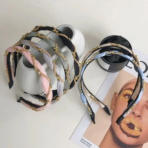 Detail of hand-woven satin headband with metal chain and rhinestone embellishments