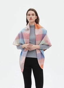 Detail view of a plaid knit triangle scarf with soft pink, blue and orange color blocking