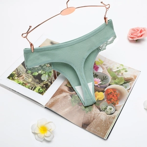Detailed view of sage green ribbed thong with floral lace trim on a rose gold hanger