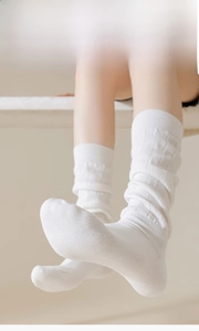 Détail de chaussettes blanches hautes avec tricot côtelé vertical fin de 200N