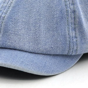 Macro shot of light blue denim fabric texture and double-stitch sewing on the hat