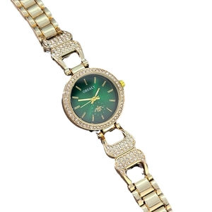 Montre quartz dorée élégante pour femme avec cadran vert foncé et accents diamants