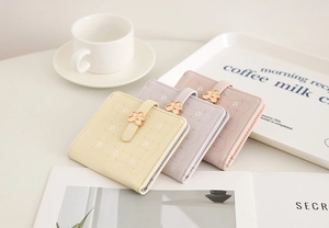 Detailed view of women's floral compact wallets in yellow, purple, and pink colors