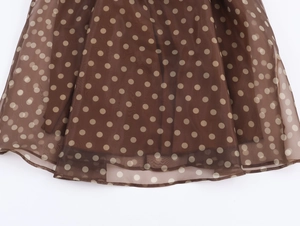 Close-up of brown polka dot organza fabric with double-layered hemline details