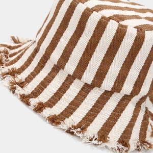Close-up of brown and white striped knit fabric with fringed edges on a sun bucket hat