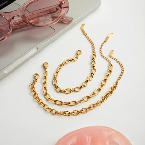 Mise à plat de trois bracelets en acier inoxydable doré avec accessoires de mode chics