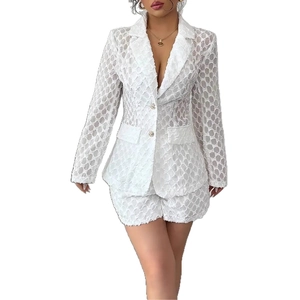Detail of white lace blazer suit showing intricate geometric mesh fabric and texture