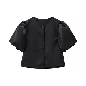 Detail of elegant black satin puff sleeve top with a decorative neck button and glossy finish