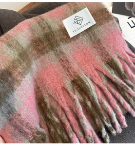 Close-up of pink and brown plaid scarf showing soft fabric texture and fringe details