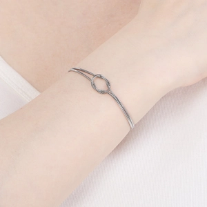 Minimalist double-layered snake chain bracelet with silver knot detail on woman's wrist